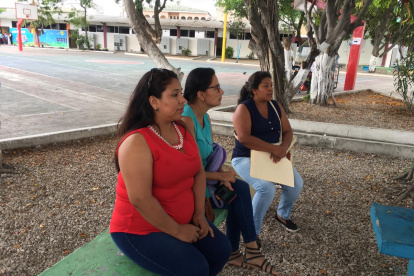Las madres esperan a que sus hijos rindan el examen, en los exteriores de la unidad educativa Provincia de Tungurahua, en el norte de Guayaquil.