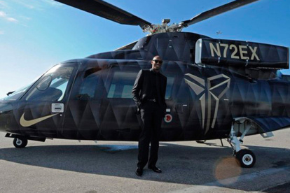 Kobe junto a su helicóptero pintado de gris y negro con su emblema de Mamba en el costado.