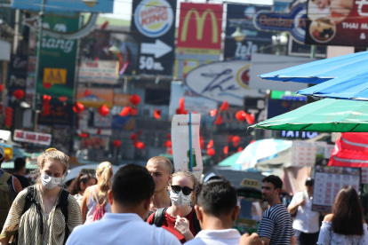 Referencial. Los turistas usan máscaras protectoras mientras caminan en la popular zona turística de Khaosan Road en Bangkok, Tailandia.