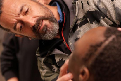 El cirujano Pedro Cavadas observa la cara de Emmanuelle, el niño congoleño de 10 años al que ha extirpado un tumor cráneo facial no maligno.