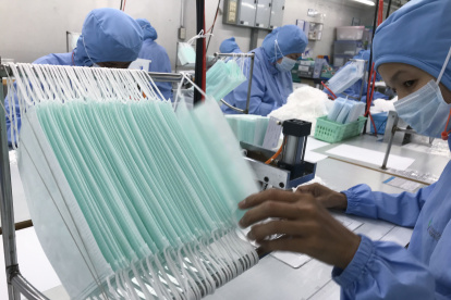 Workers produce masks at the Thai Hospital Product Company Ltd. factory in Bangkok on January 30, 2020. - A Thai surgical mask factory, producing 10 million masks a month, increased working hours to cope with the rising demand following an outbreak of SARS-like virus in China, with their product exported mostly to US and Europe the rest sold on the domestic market. (Photo by Jonathan KLEIN / AFP)