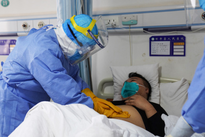 This photo taken on January 28, 2020 shows a medical staff member checking a patient infected by the novel coronavirus inside an isolation ward at a hospital in Zouping in China"s easter Shandong province. - China faced deepening isolation over its coronavirus epidemic on February 1 as the death toll soared to 259, with the United States leading a growing list of nations to impose extraordinary Chinese travel bans. (Photo by STR / AFP) / China OUT