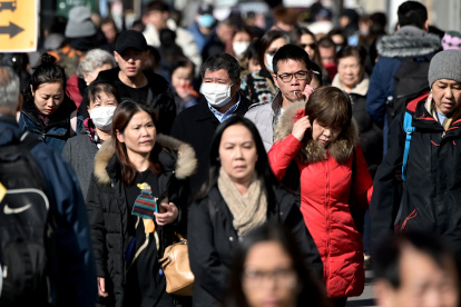 People wear surgical masks in fear of the coronavirus in Flushing, a neighborhood in the New York City borough of Queens on February 3, 2020. - China"s top leadership on Monday admitted "shortcomings and difficulties" in its response to the coronavirus outbreak and the government said it "urgently" needed medical supplies to battle the outbreak which has killed more than 360 people.The virus has since spread to more than 20 countries despite many governments imposing unprecedented travel bans on arrivals coming from China. (Photo by Johannes EISELE / AFP)