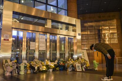 Wuhan (China), 07/02/2020.- A citizen bows in front of a makeshift memorial, to pay tribute to Dr. Li Wenliang at Li"s hospital in Wuhan in central China"s Hubei province, 07 February 2020. Li, regarded a whistleblower on the pneumonia outbreak, died of the novel coronavirus on late 07 February. Li was one of the first to raise concerns about the coronavirus outbreak in Wuhan, before contracting the infection himself. The virus has killed so far at least 638 people and over 31,000 others were confirmed infected, mostly in China. EFE/EPA/SHI ZHI CHINA OUT CHINA HEALTH CORONAVIRUS LI WENLIANG MOURNING
