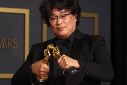 Bong Joon Ho juega con sus dos estatuillas por Mejor director y guion.