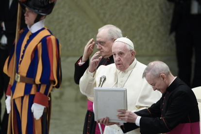 Pope Francis (C), flanked by Monsignor Leonardo Sapienza (Rear C) and Argentine priest, Monsignor Luis Maria Rodrigo Ewart (R), crosses himself during the weekly general audience on February 12, 2020 at Paul-VI hall in the Vatican. (Photo by Filippo MONTEFORTE / AFP)