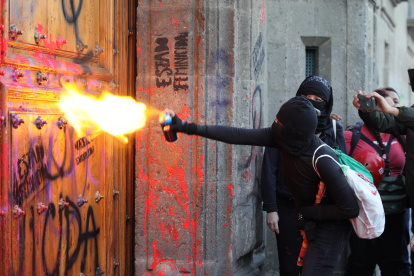 Un centenar de mujeres pintaron la fachada y una de las puertas de Palacio Nacional mexicano para protestar contra los feminicidios en México.