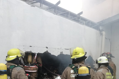 Bomberos ingresan al edificio para calmar las llamas.