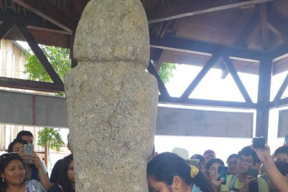 Una turista muestra su fe al tótem pidiendo un embarazo.