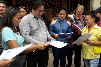 Padres de familias  muestran las hojas de los aciertos que tuvieron sus hijos en la primera prueba.