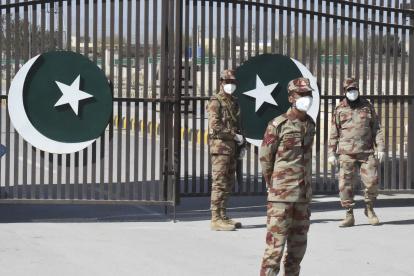 Pakistani soldiers wear facemasks on the closed border of Pakistan-Iran in Taftan on February 25, 2020 as fears over the spread of the COVID-19 coronavirus escalate following an outbreak in neighbouring Iran. - The Iranian outbreak where at least 15 people have already died -- the highest death toll in any country outside of China -- has aggravated already frayed nerves in neighbouring Afghanistan and Pakistan. (Photo by Banaras KHAN / AFP)