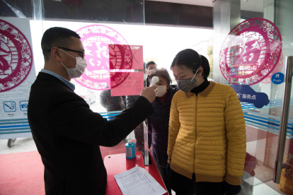Un cliente a quien le tomaron la temperatura en la entrada de un banco en Nantong, en la provincia oriental china de Jiangsu.