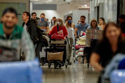 SAO PAULO. Pasajeros usan máscaras como precaución contra la propagación del nuevo coronavirus COVID-19 durante su llegada, hoyjueves, al Aeropuerto Internacional de esta ciudad.