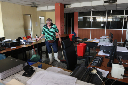 Personal de mantenimiento limpia la la oficina de la secretaría general de la carrera de Comercio Exterior, que amaneció inundada.