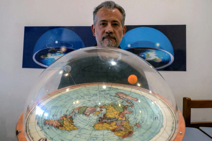 Brazilian self-avowed flat-Earth conspiracy theorist Anderson Neves holds a model of the flat earth surrounded by a dome during an interview with AFP in Sao Paulo, Brazil, on February 13, 2020. - Eleven million people in Brazil, 7% of its population, believe that the Earth is flat, according to Datafolha polling institute. (Photo by Florence GOISNARD / AFP)