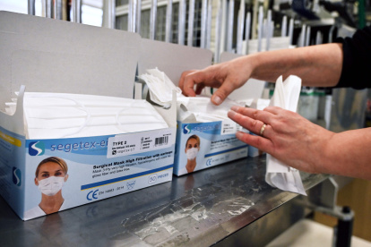 An employee packs repiratory protective face masks on an assembly line at the Valmy protective mask manufacturer plant in Mably, central France, on February 28, 2020, amid the spread of COVID-19, the novel coronavirus. The spread of the new coronavirus to Europe has boosted the activity of Valmy, one of the French protective face mask manufacturers, with the number of employees in the production plant and warehouse rising from around 20 to 60 in the past month. / AFP / PHILIPPE DESMAZES

 FRANCE-HEALTH-VIRUS-MANUFACTURING-COMPANY