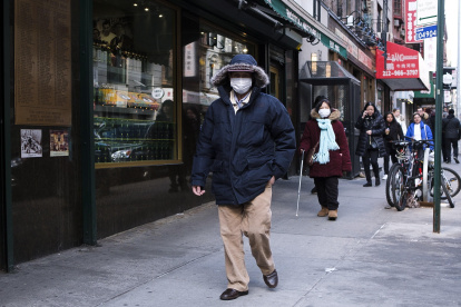 Personas usan mascarillas al caminar por el barrio chino de Nueva York.