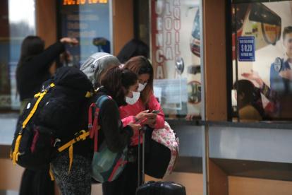 Viajeras usan mascarilla en la terminal terrestre de Quitumbe.