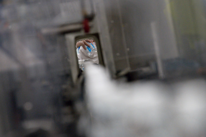 An employee of the pharmaceutical laboratory "Laboratoires Gilbert" works on a production chain of hydroalcoholic solution in Plouedern, northwestern France on March 4, 2020 as France has confirmed 204 cases of the novel coronavirus. - Fears of catching the virus have sparked a run on masks as well as sanitising hand gel in France, leading some stores and online retailers to hike prices. Finance Minister Bruno Le Maire said earlier on March 4, 2020 that he had ordered France"s consumer and anti-fraud watchdog to open an investigation after reports that prices had doubled or even tripled. (Photo by Loic VENANCE / AFP)