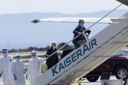 Los pasajeros del crucero Grand Princess reciben ayuda para abordar un avión en el Aeropuerto Internacional de Oakland, California. Al menos 21 personas a bordo del barco dieron positivo por coronavirus.