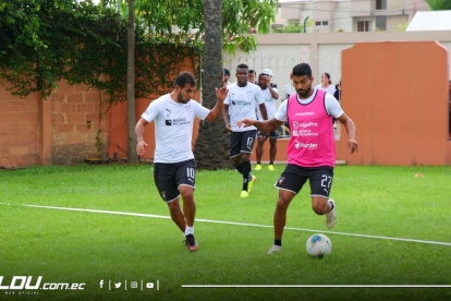 Junior Sornoza (i) y Rodrígo Aguirre, de Liga, antes de la suspensión de los entrenamientos.