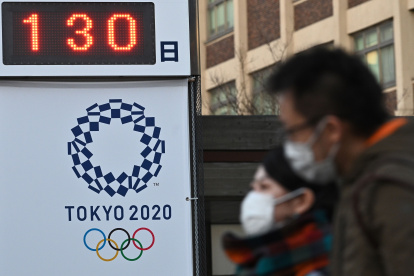 Transeúntes japoneses pasan por una de las edificaciones de Tokio que llevan la cuenta regresiva del inicio de los Juegos Olímpicos 2020.

 OLY-2020-TOKYO-HEALTH-VIRUS
