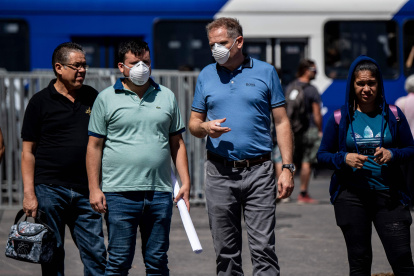 Transeúntes chilenos caminan por las calles de Santiago donde se extreman cuidados para el contagio.