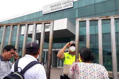 Medidas. Un policía y un servidor restringían el ingreso a quienes acudían a la Unidad de la Florida, en Guayaquil.