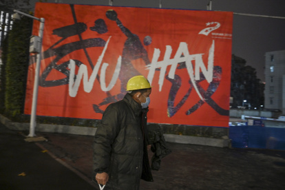 A man wearing a protective facemask walks along a street in Wuhan on January 26, 2020, a city at the epicentre of a viral outbreak that has killed at least 56 people and infected nearly 2,000. - China on January 26 expanded drastic travel restrictions to contain an epidemic that has killed 56 people and infected nearly 2,000, as the United States, France and Japan prepared to evacuate their citizens from a quarantined city at the outbreak"s epicentre. (Photo by Hector RETAMAL / AFP)