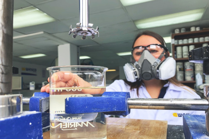 Una trabajadora de Wesco revisa la calidad del gel antibacterial que han empezado a producir.