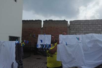 Chinto Espinoza colgando la ropa en el patio de su casa.