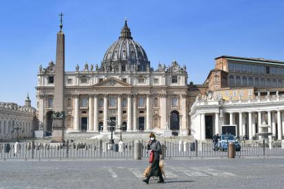 ROMA. Una mujer atraviesa la plaza San Pedro, en silencio absoluto, ante la cuarentena que se impone en Italia por el coronavirus.