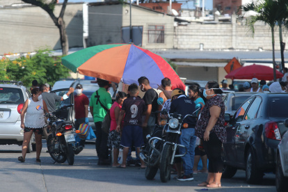 Martha de Roldós. En la foto se ve a un niño y una persona que se han bajado la mascarilla, además nadie se preocupa por poner un metro de distancia,
Agencia (ag-extra)
