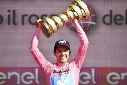 Richard Carapaz sostiene el trofeo del Giro de Italia logrado el año anterior.