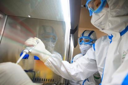 This photo taken on February 19, 2020 shows laboratory technicians testing samples of virus at a laboratory in Hengyang in China"s central Henan province. - The death toll from the COVID-19 coronavirus epidemic jumped to 2,112 in China on February 20 after 108 more people died in Hubei province, the hard-hit epicentre of the outbreak. (Photo by STR / AFP) / China OUT