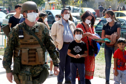En el marco del coronavirus, un grupo de personas hacen fila para vacunarse contra la influenza en el Estadio Bicentenario de la Florida este sábado, en Santiago de Chile. EFE/Sebastián Silva