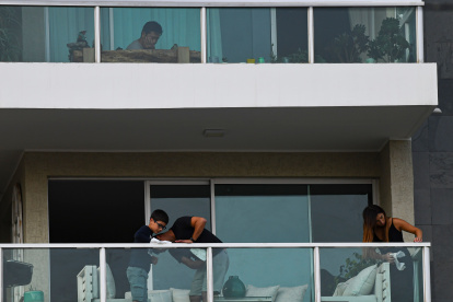 A family clean their balcony in Santiago, Chile, march 28, 2020.  More than 1.3 million people of seven of the main communes of Santiago were placed into total quarantine aiming to curb the spread of the novel coronavirus, COVID-19. / AFP / MARTIN BERNETTI

 CHILE-HEALTH-VIRUS