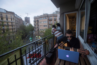 BARCELONA. Un músico ofrece a sus vecinos un concierto desde su balcón en el decimosexto día de aislamiento.