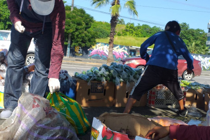 En las aceras instalan sus cajas de cartón llenas de frutas para vender a los conductores que se detienen en el semáforo en rojo.