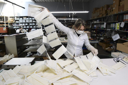 An employee controls surgical masks at a leather workshop turned into a mask factory, close to Vigevano, Lombardy, on March 19, 2020 during the country"s lockdown within the new coronavirus pandemic. - A crafts company specialized in the production of leather goods and accessories for the automotive and clothing sector, has now turned its activity to the production of surgical masks on behalf of a company from the nearby town of Galliate, in the wake of the needs following the coronavirus pandemic. (Photo by MIGUEL MEDINA / AFP)
