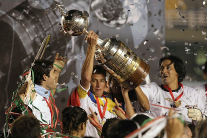 Patricio Urrutua (C) of Liga Deportiva Universitaria (LDU) raises the trophy after defeating Fluminense to win their Copa Libertadores final soccer match in Maracana stadium in Rio de Janeiro July 2, 2008.     REUTERS/Sergio Moraes (BRAZIL) SOCCER-LATAM/LIBERTADORES