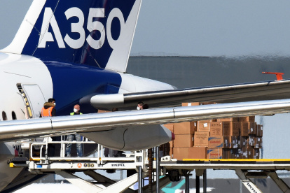 Trabajadores descargan del avión Airbus A350-1.000 máscaras faciales procedentes de China.