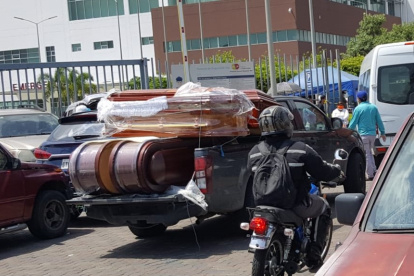 Camionetas llegan cargadas de ataúdes a los exteriores del hospital.