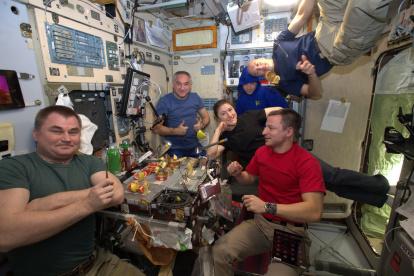 Estación Espacial Internacional. Astronautas celebrando una comida especial.