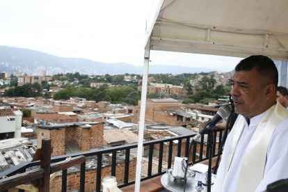 MEDELLÍN. El sacerdote Wilson Grajales, de la Parroquia Santuario del Divino Niño, celebra una misa este jueves en la terraza de su casa en el barrio Antonio Nariño de la comuna 13.