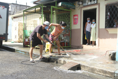 Ciudadanos de la 12 y la B en Guayaquil realizan la limpieza de sus cuadras como medida de prevención del virus.