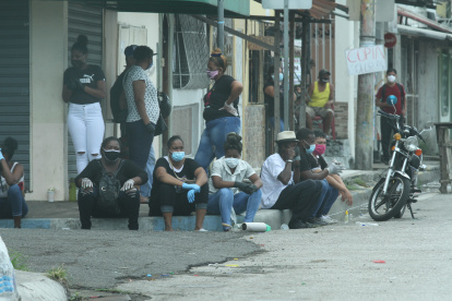 Ciudadanos en Guayaquil toman sus precauciones al usar mascarilla al exterior de un camposanto de la ciudad.