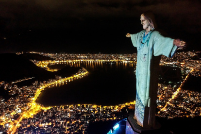 Vista aérea de la estatua del Cristo Redentor con una proyección de trabajadores de la salud, durante un acto religioso para celebrar el domingo de Pascua, este domingo, en el Monte Corcovado (Brasil). EFE/ Antonio Lacerda