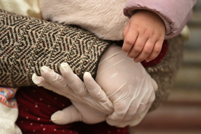 A mother wearing gloves holds her son"s hand after completing 14-days of quarantine at a hotel during government-imposed nationwide lockdown as a preventive measures against the spread of the COVID-19 coronavirus, on the outskirts of Srinagar on April 6, 2020. (Photo by Tauseef MUSTAFA / AFP)