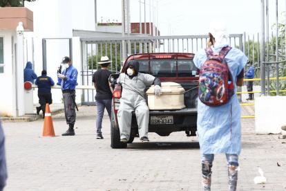 En los exteriores del Hospital Guasmo Sur de Guayaquil, personas llegan con féretros para retirar a sus familiares fallecidos.